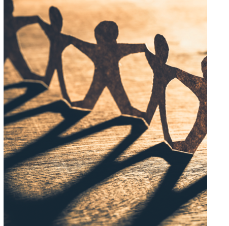 Menschen verschiedener Hintergründe stehen im Kreis und legen die Hände zusammen – Symbol für soziale Verantwortung, Zusammenhalt und Teamwork.