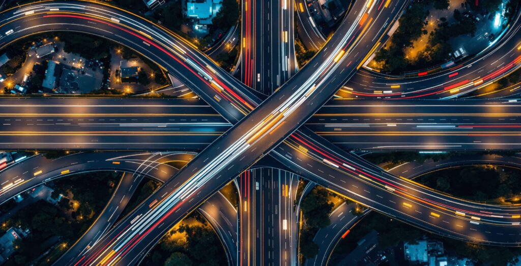 Das Bild steht für die globale Vernetzung über Wide Area Networks (WAN). Die Straßen symbolisieren Datenautobahnen, die Lichtspuren den ständigen Informationsfluss zwischen Standorten. Wie bei einer komplexen Infrastruktur sorgen wir mit unserer WAN-Beratung dafür, dass Unternehmen die optimale Route für ihre Datenströme nutzen – sicher, effizient und zukunftssicher.
