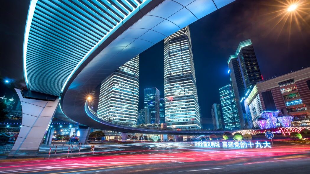 Futuristische Skyline mit beleuchteten Hochhäusern und schneller Verkehr in China als Symbol für SD WAN Lösungen mit hoher Geschwindigkeit und Stabilität